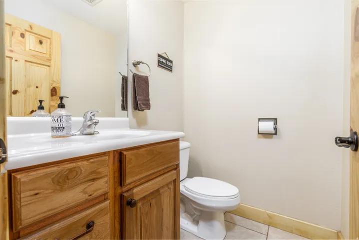 Bathroom vanity featuring wood-finish cabinetry, a white integrated sink, and a chrome faucet