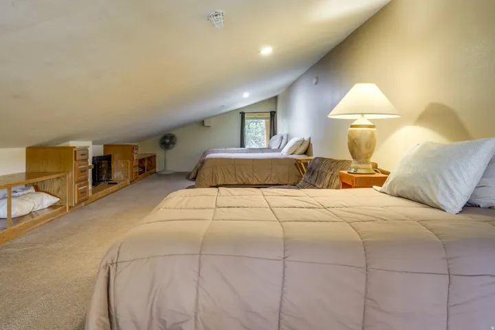 Carpeted sleeping area with multiple recessed lights and a sloped ceiling