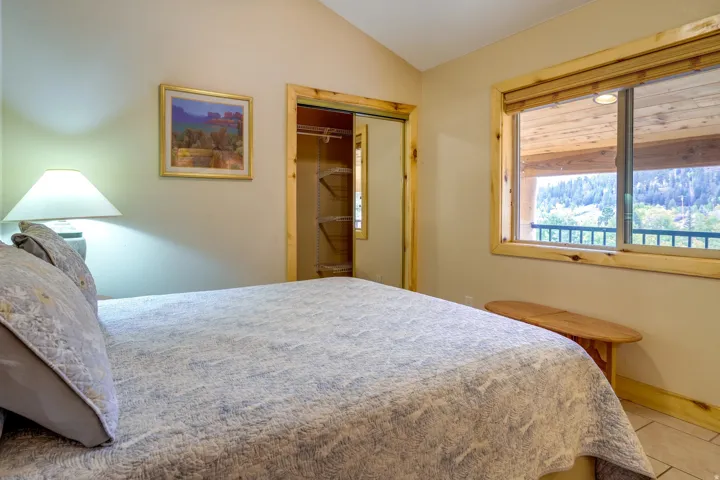 Bedroom featuring a vaulted ceiling and direct outdoor access through a sliding glass door