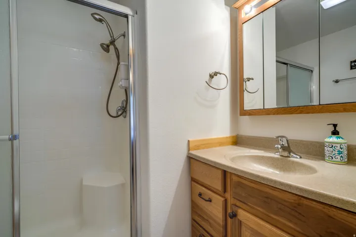 Bathroom featuring a wood-finish vanity with a built-in sink and laminate countertop