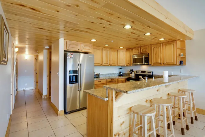 Kitchen featuring wood-finish cabinetry, granite-style countertops, and stainless steel appliances