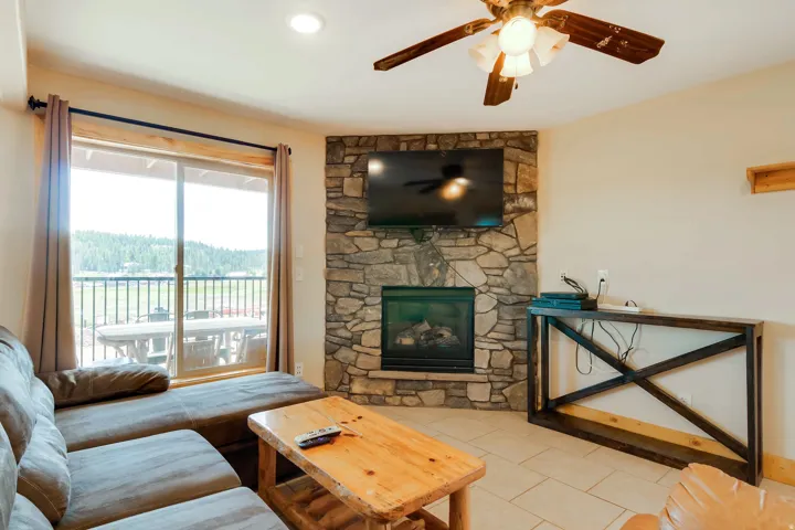 Stone-faced fireplace with an integrated television niche and a glass-front firebox