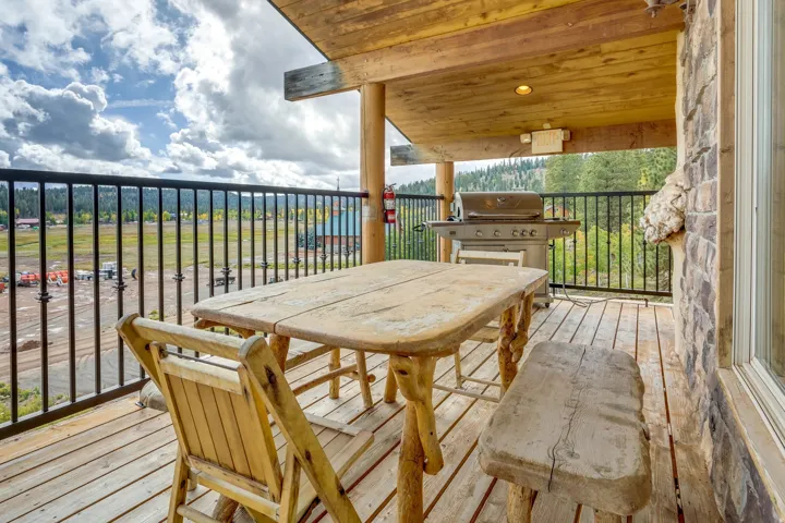 Covered wood-plank deck with a black metal railing