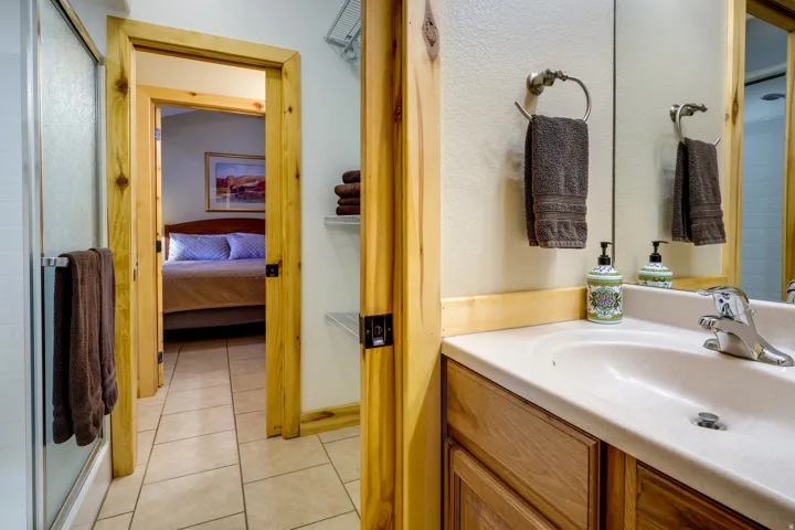 Bathroom vanity featuring a single basin sink and chrome faucet