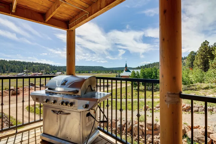 Covered outdoor deck with exposed wood ceiling beams and natural wood posts