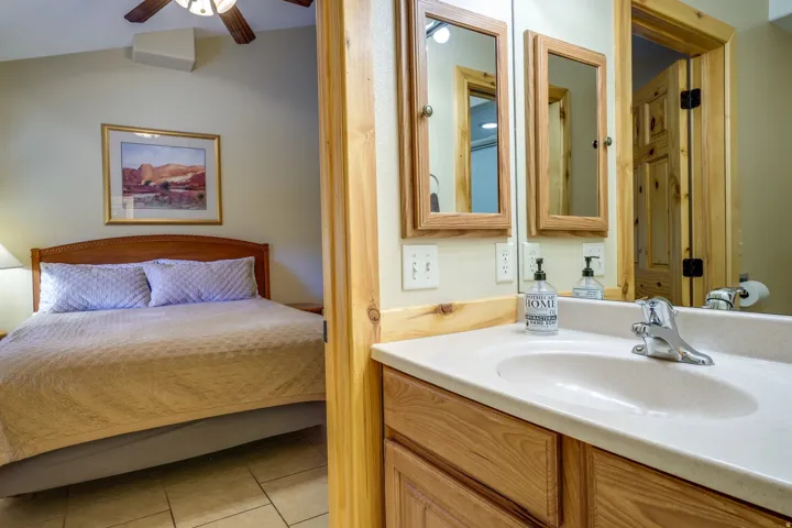 Bathroom vanity featuring a light-toned countertop, undermount sink, and chrome faucet