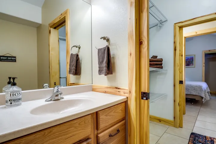 Bathroom vanity featuring an integrated sink, polished chrome faucet, and a large wall-mounted mirror
