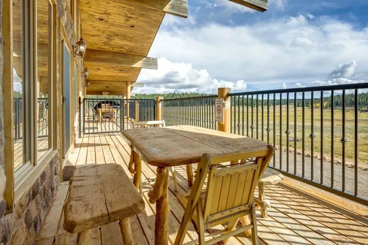 Expansive outdoor deck featuring wood-finish flooring and a black metal railing