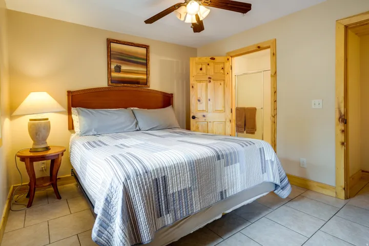 Bedroom featuring a wooden headboard, light-toned wall paint, and overhead ceiling fan