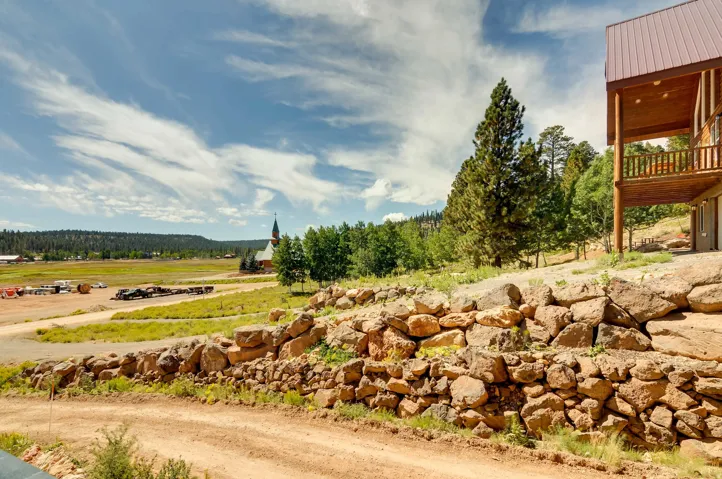 Elevated property with a multi-level rock retaining wall and a dirt access road