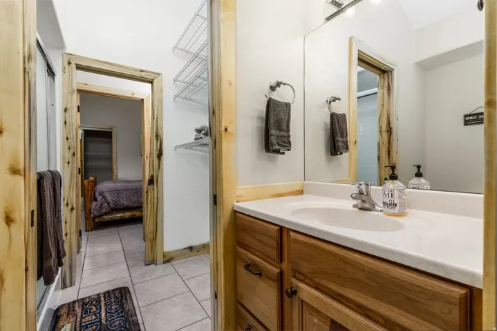 Bathroom vanity featuring a single basin sink, chrome faucet, and wood-finish cabinetry