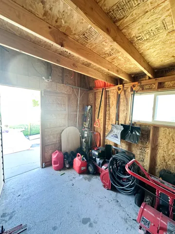 Utility shed with exposed wood framing and a concrete floor