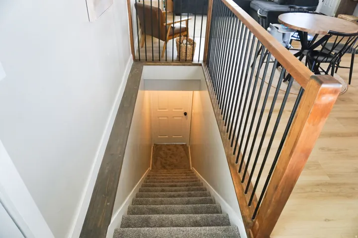 Staircase featuring wood-finish handrails and black metal balusters