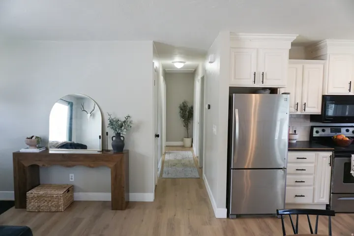 Modern kitchen featuring white cabinetry, stainless steel appliances, dark countertops, and a white subway tile backsplash