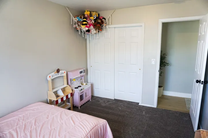 Carpeted room with a closet featuring bi-fold doors