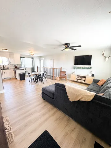 Open concept living area featuring wood-finish flooring, a ceiling fan, and recessed lighting