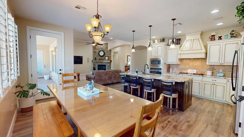 Open-concept living space featuring a gourmet kitchen with a central island, integrated appliances, and a decorative range hood