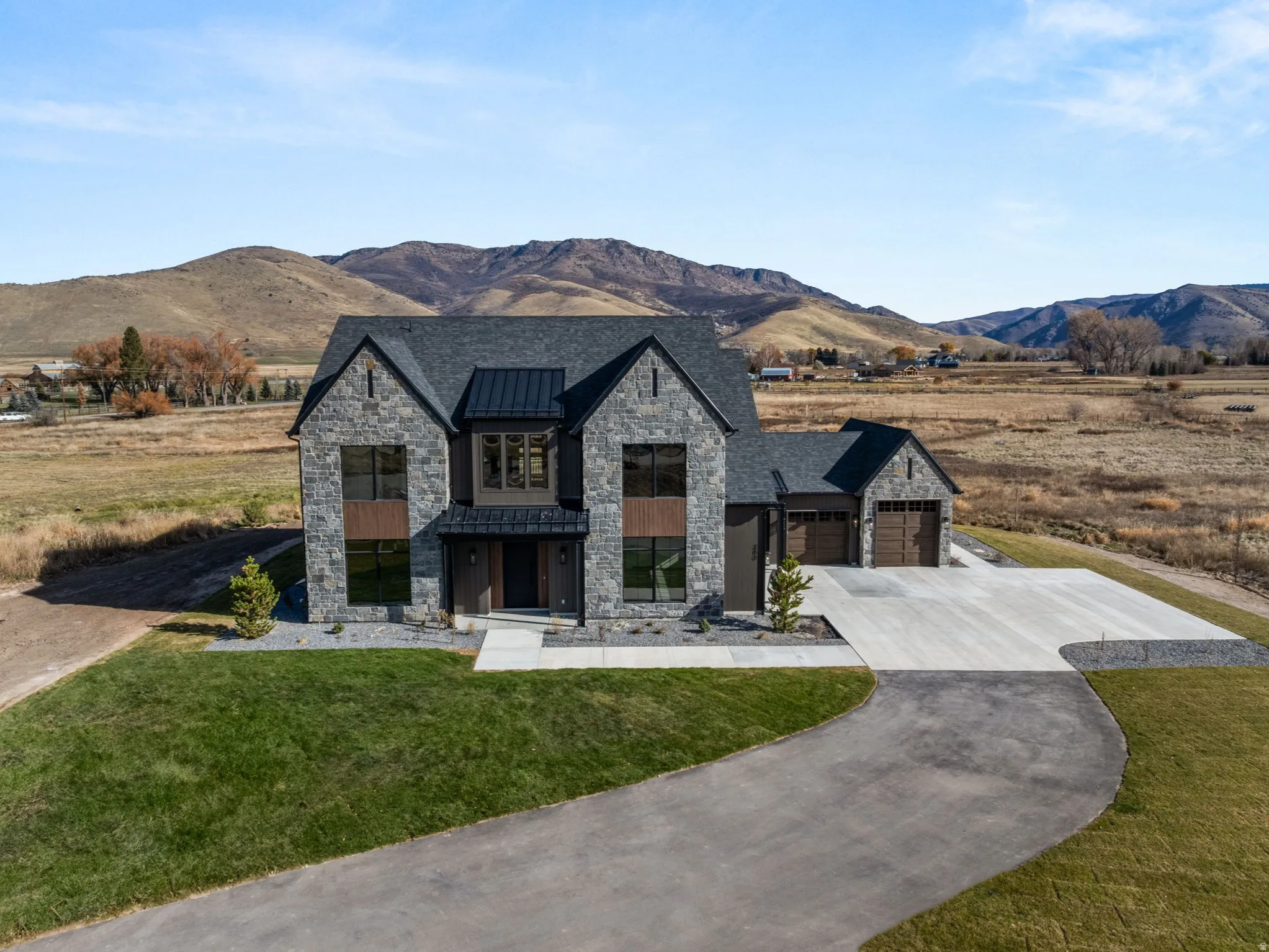 Contemporary stone and wood-clad exterior with dark-framed windows