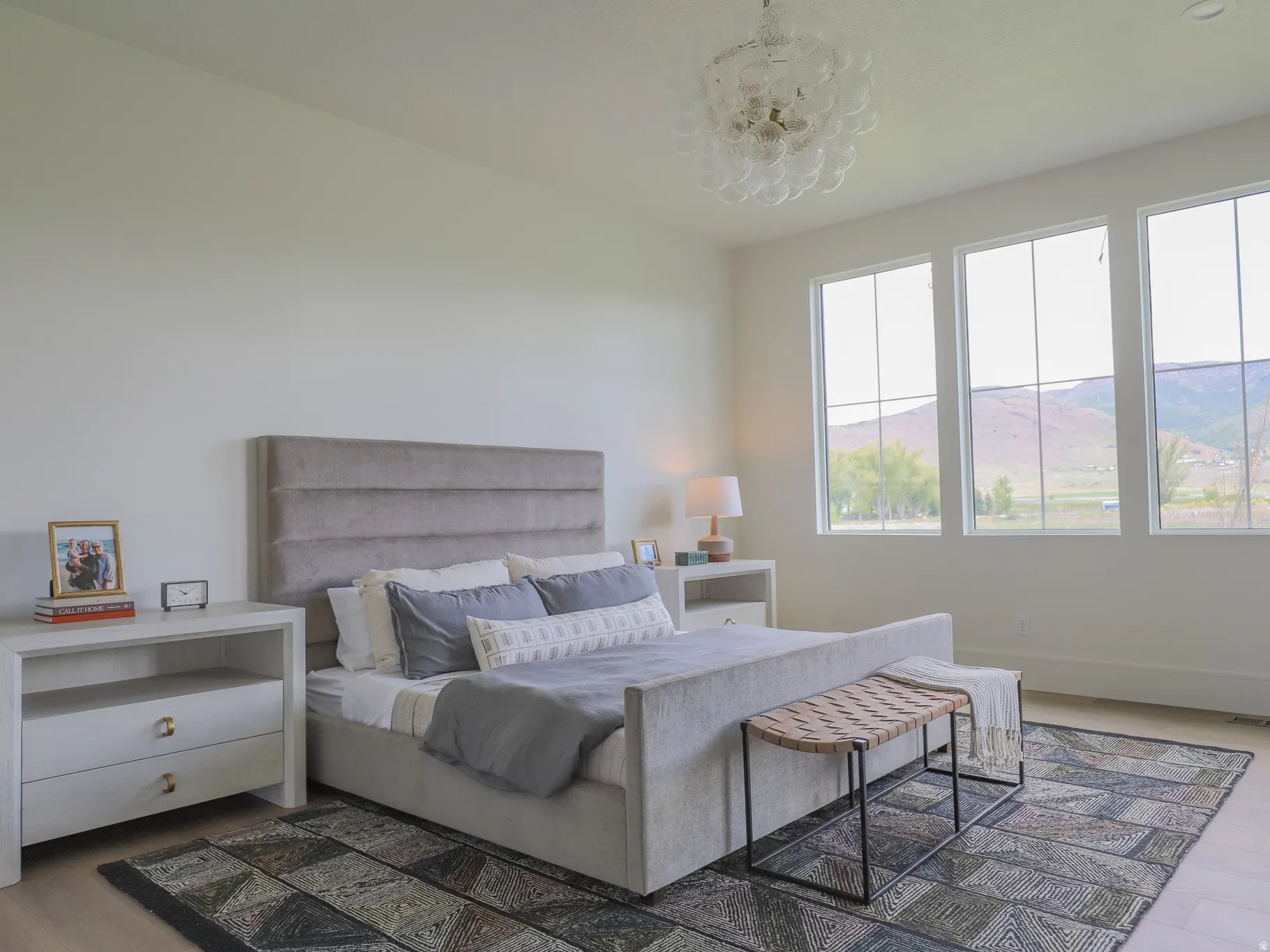 Spacious room featuring light wood-finish flooring and a light-toned area rug