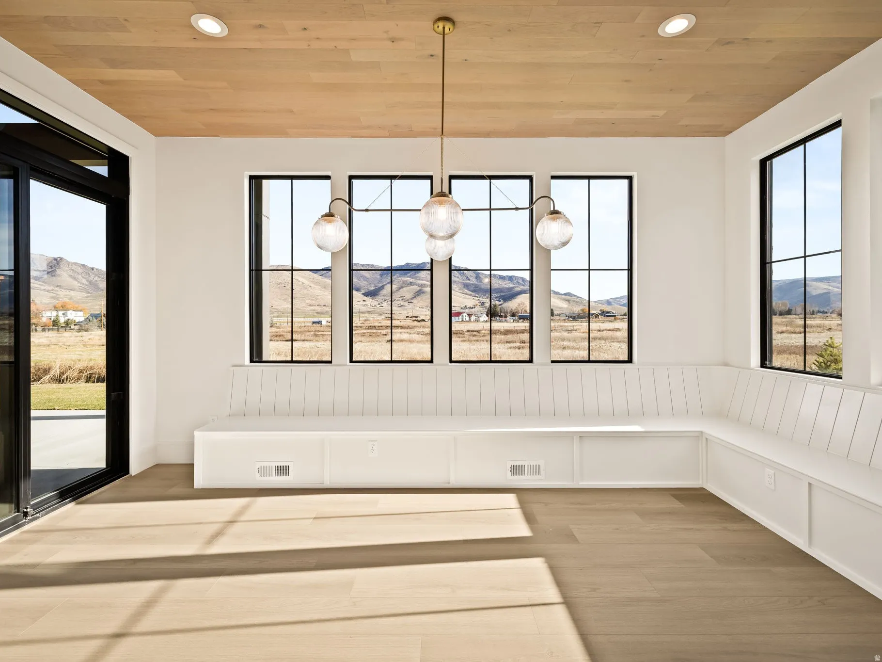 Bright room featuring panoramic windows, built-in bench seating, wood-finish flooring, a wood-paneled ceiling, and recessed lighting