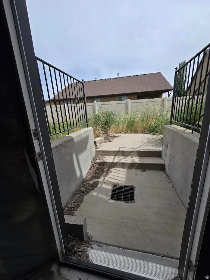 Concrete patio area with a grated drain and two sets of concrete steps