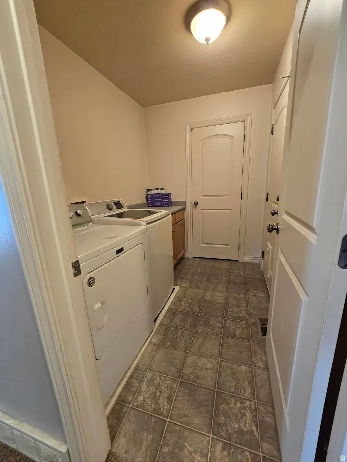 Laundry area featuring tiled flooring, a built-in counter with cabinetry, and an overhead flush mount light fixture