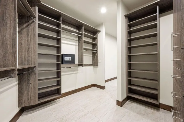 Custom wood-finish cabinetry featuring extensive shelving and hanging rods