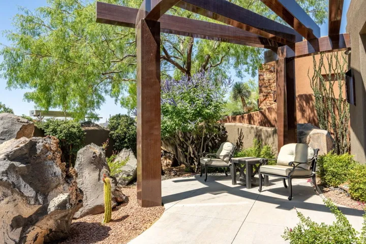 Outdoor patio featuring a contemporary wood pergola and concrete paving