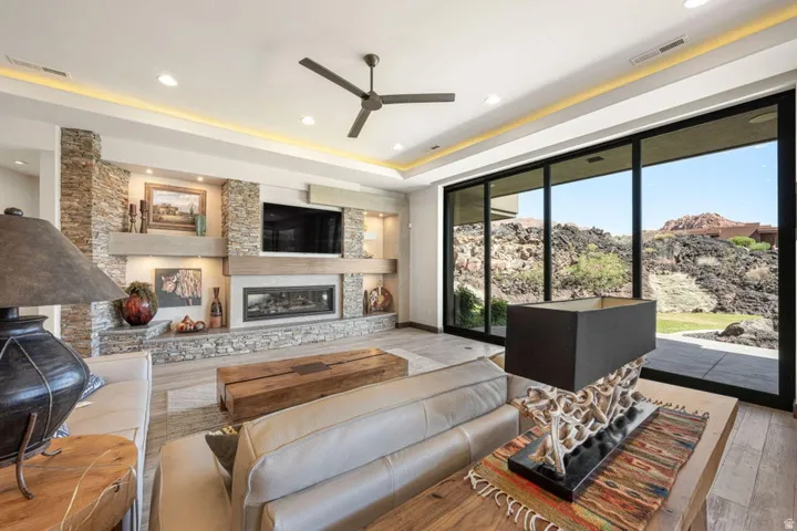 Living area featuring a floor-to-ceiling stone-faced fireplace wall with integrated media storage and a linear gas fireplace