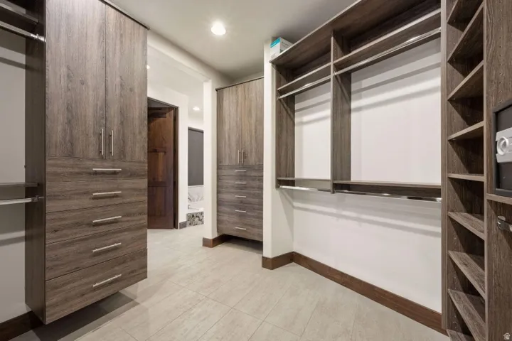 Custom closet system with wood-finish cabinetry, integrated drawers, shelving, and hanging rods