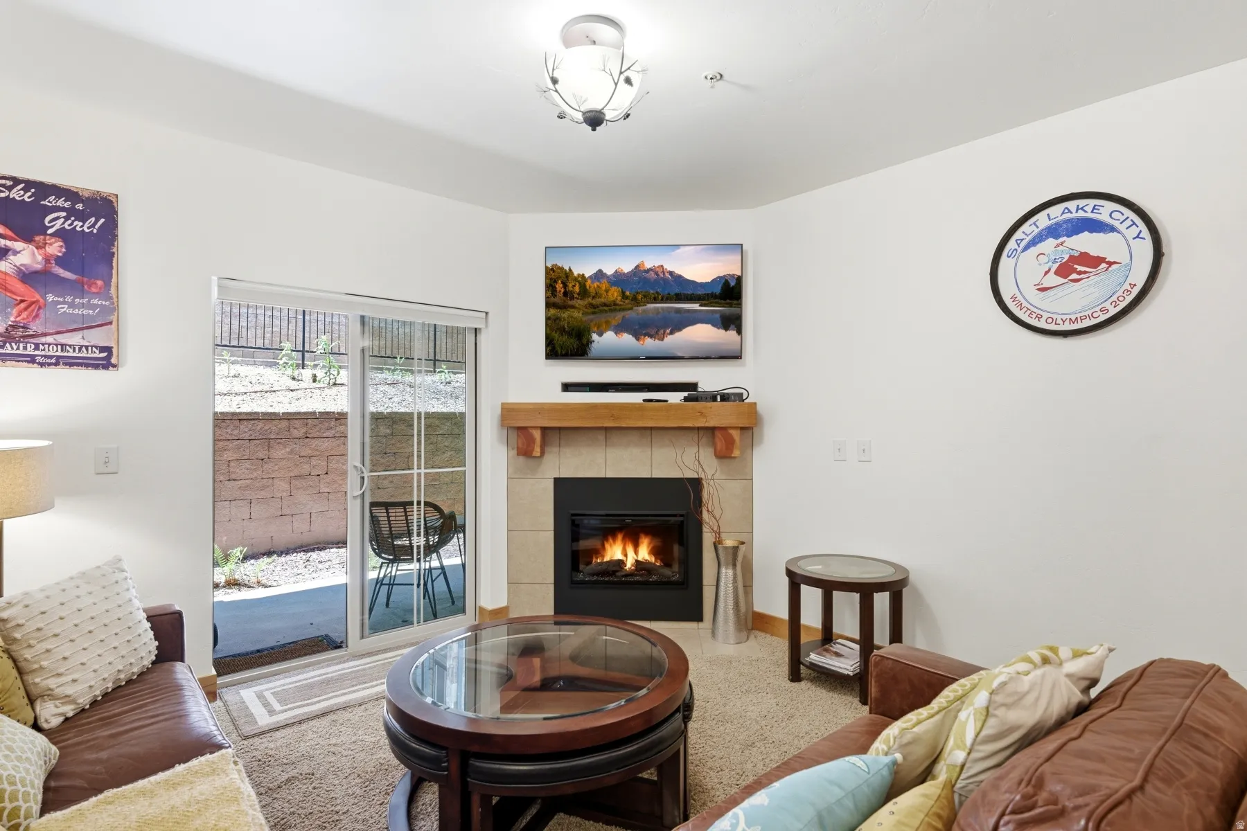 Living area featuring a corner fireplace with tile surround and wood mantel