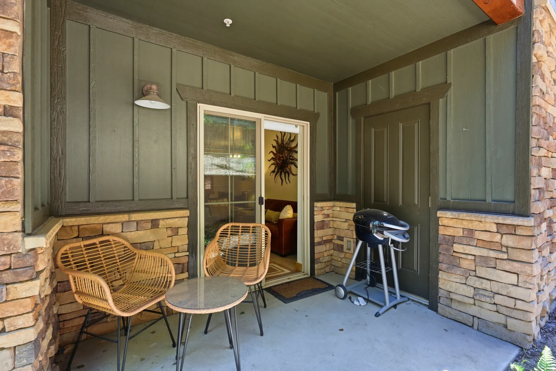 Covered outdoor patio featuring a concrete surface and stone veneer accents