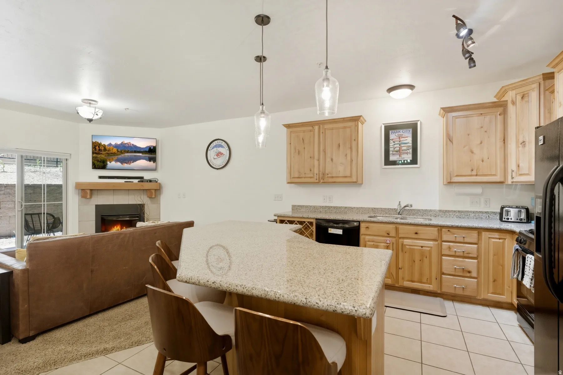 Open-concept kitchen featuring wood cabinetry, light-toned countertops, and tile flooring