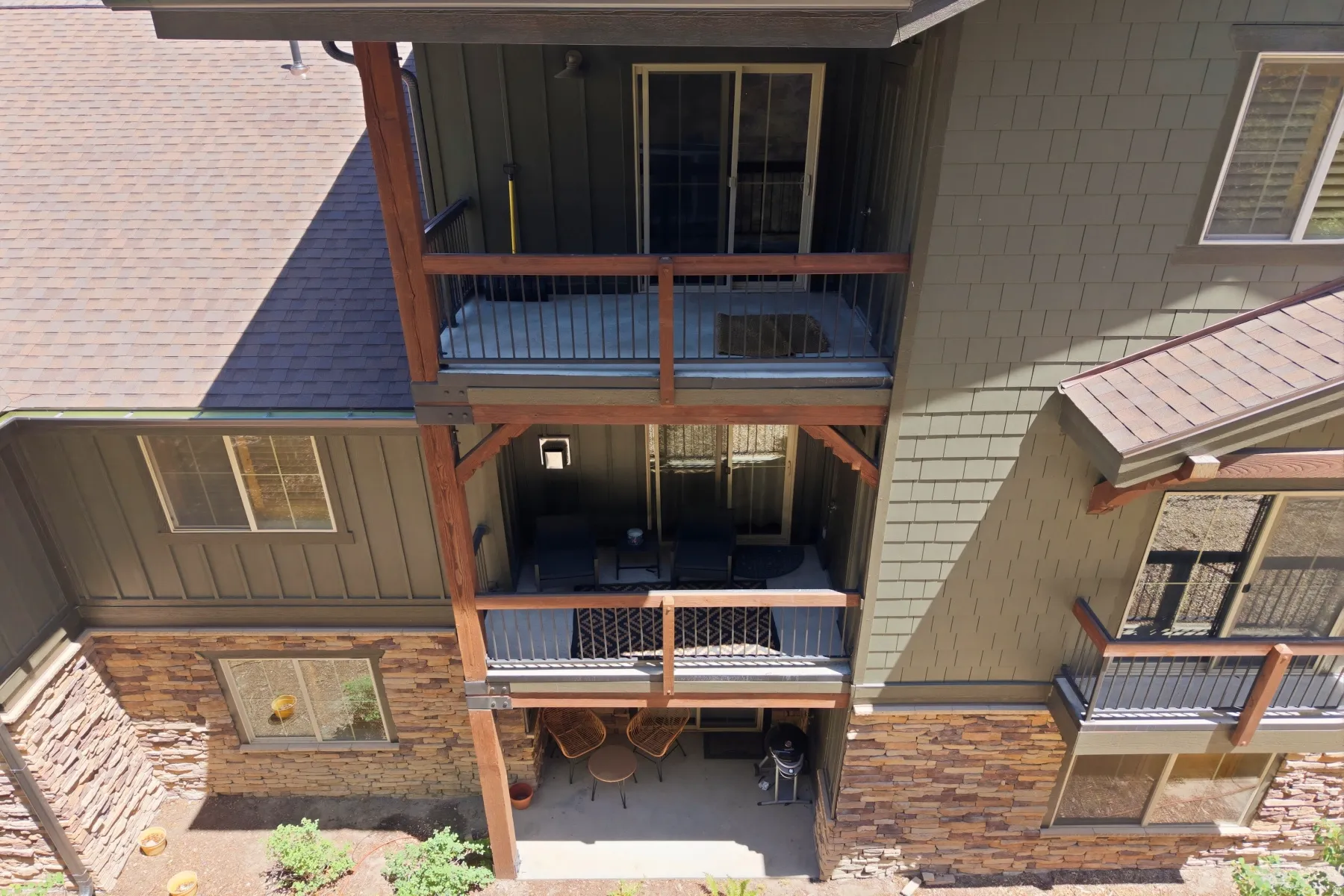 Multi-level exterior featuring stacked balconies with wooden railings and metal infill