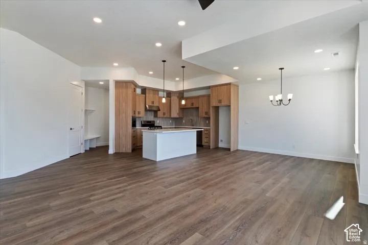 Open-concept living space featuring wood-finish flooring, recessed lighting, and a modern kitchen
