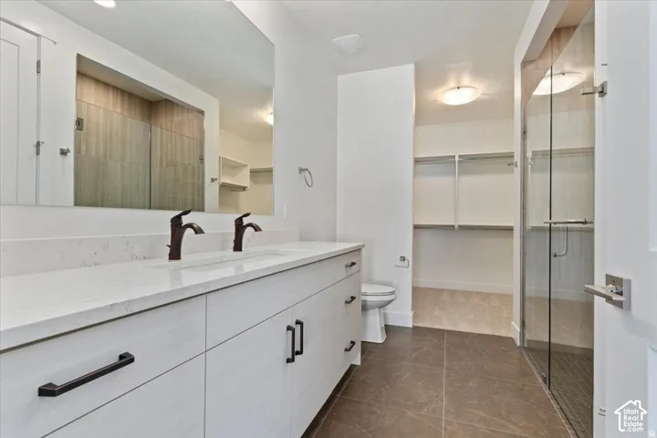Dual vanity with white cabinetry, bronze hardware, and a light-toned countertop