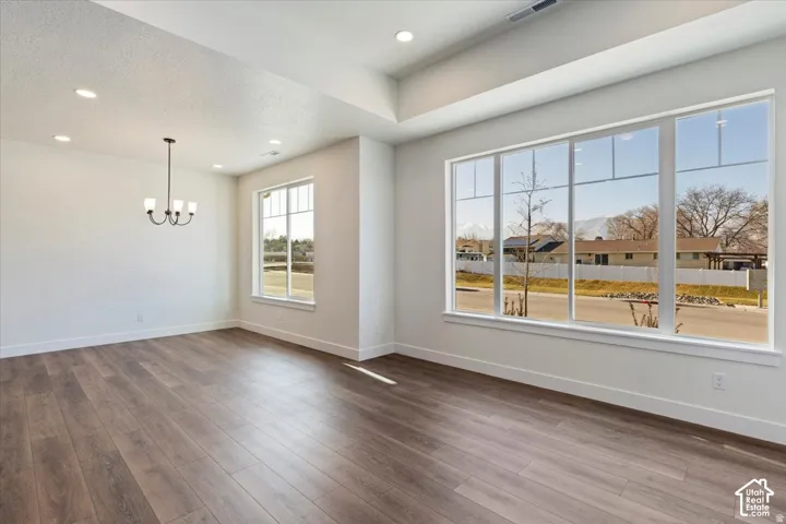 Spacious interior featuring wood-finish flooring, crisp white walls, and a recessed ceiling with integrated lighting