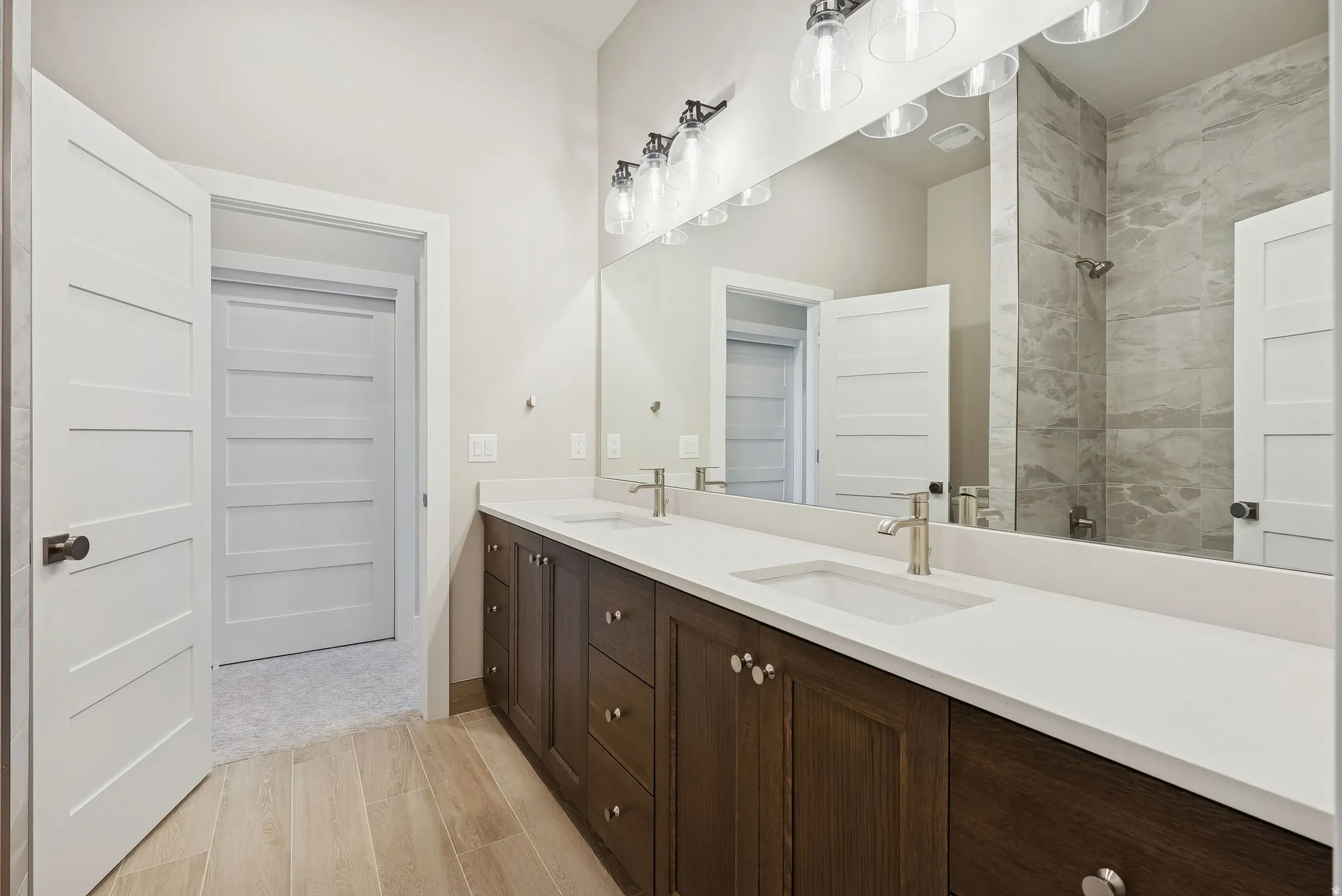 Dual vanity with a white countertop and wood-finish cabinetry