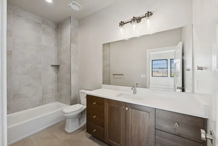 Bathroom featuring a full-size tub with tiled surround and built-in niche