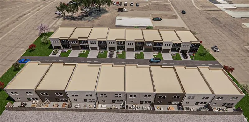 Modern multi-story townhomes featuring contemporary facades with varying exterior finishes, individual garage entries, and private rear patios