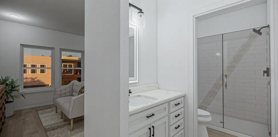 Bathroom vanity featuring a single basin, stone countertop, and light wood-finish cabinetry with dark hardware