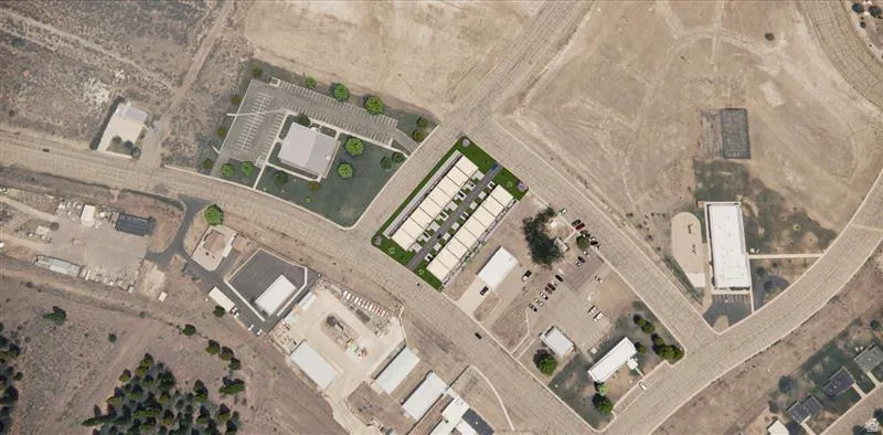 Aerial view showcasing a rectangular multi-unit residential complex with individual parking spaces