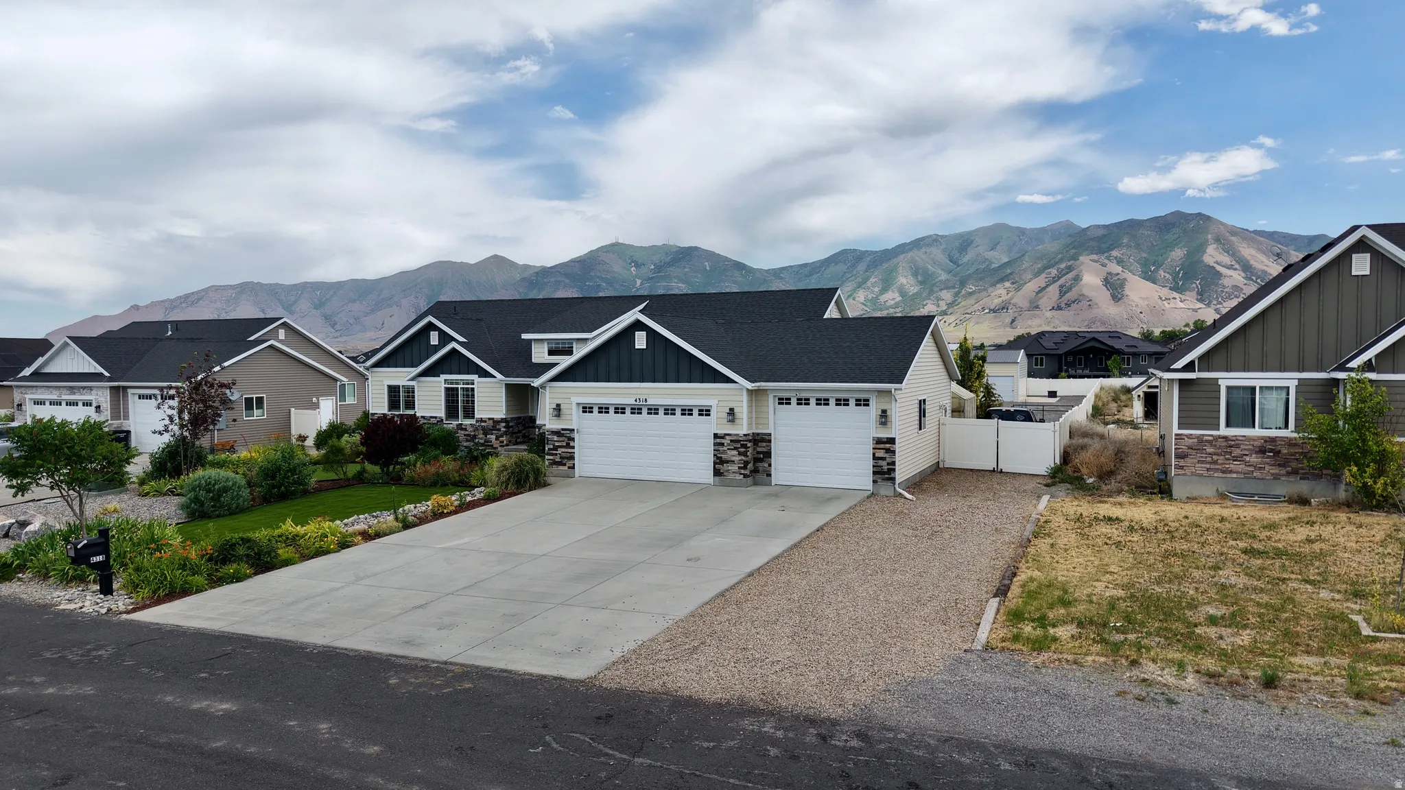 Ranch-style residence featuring a two-car garage, stone and siding exterior, and a concrete driveway