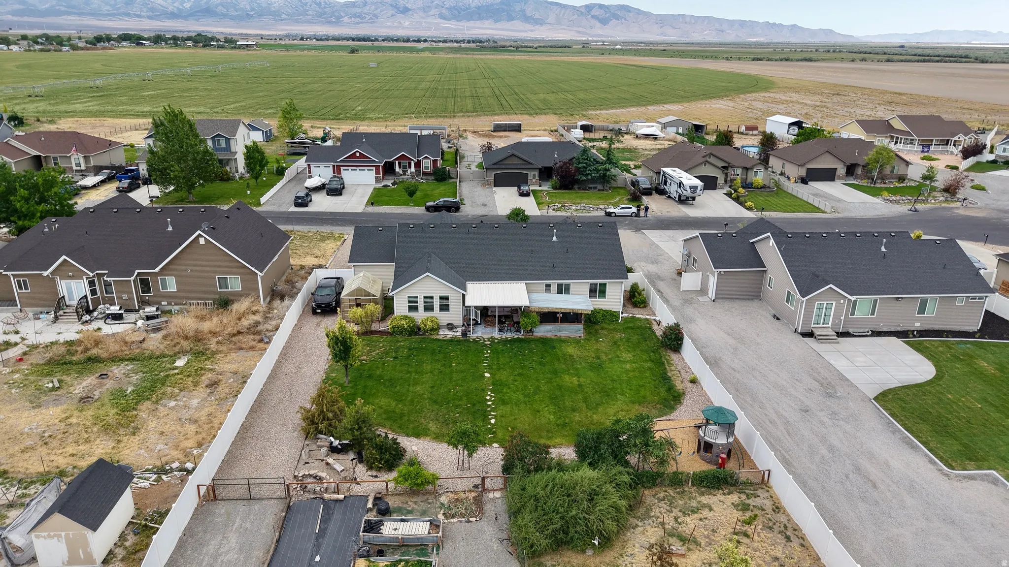 Expansive property featuring a meticulously maintained lawn, mature landscaping, and a fenced perimeter