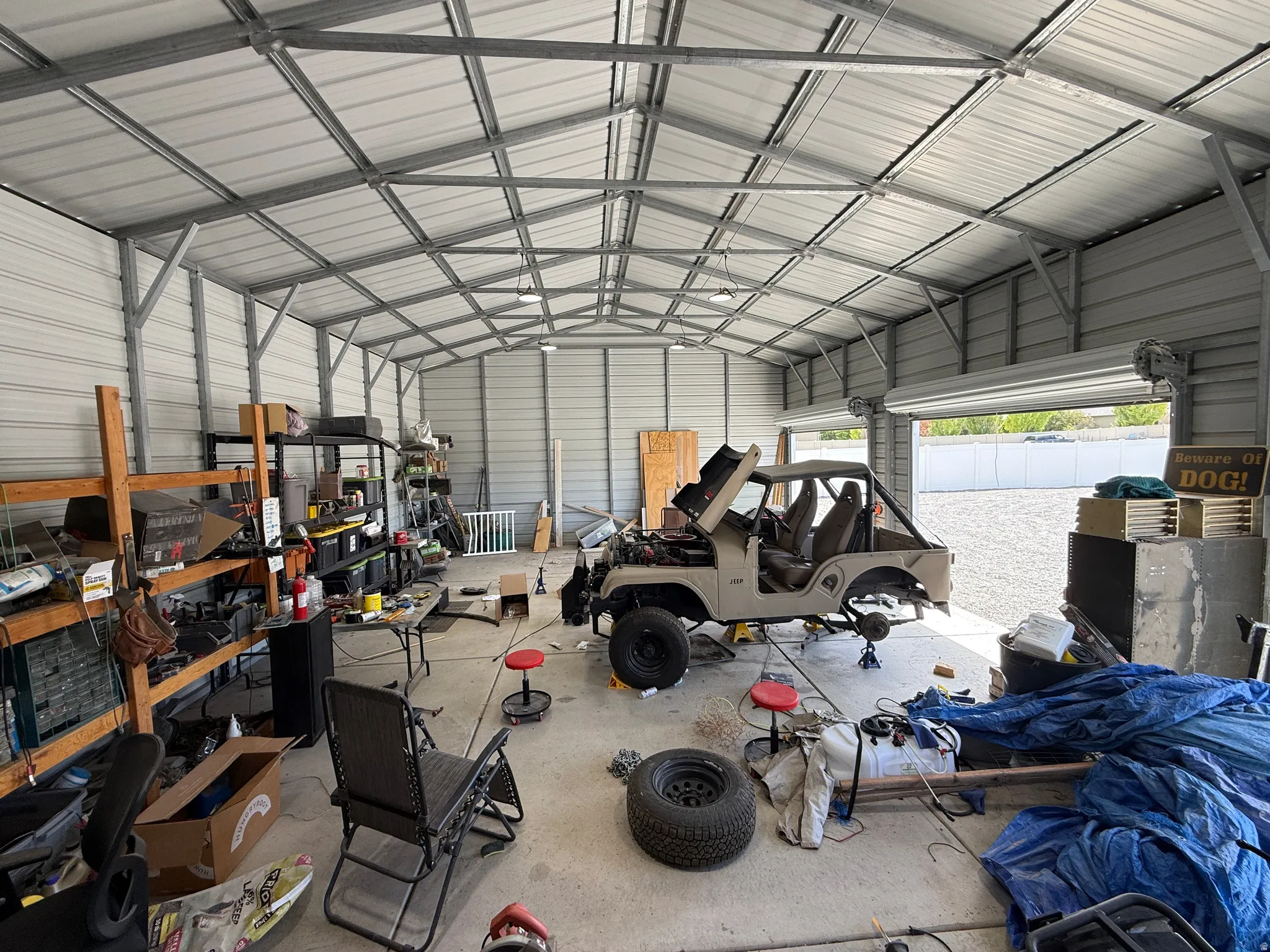 Spacious metal building featuring a vaulted ceiling with exposed framing, corrugated metal walls, and a concrete floor