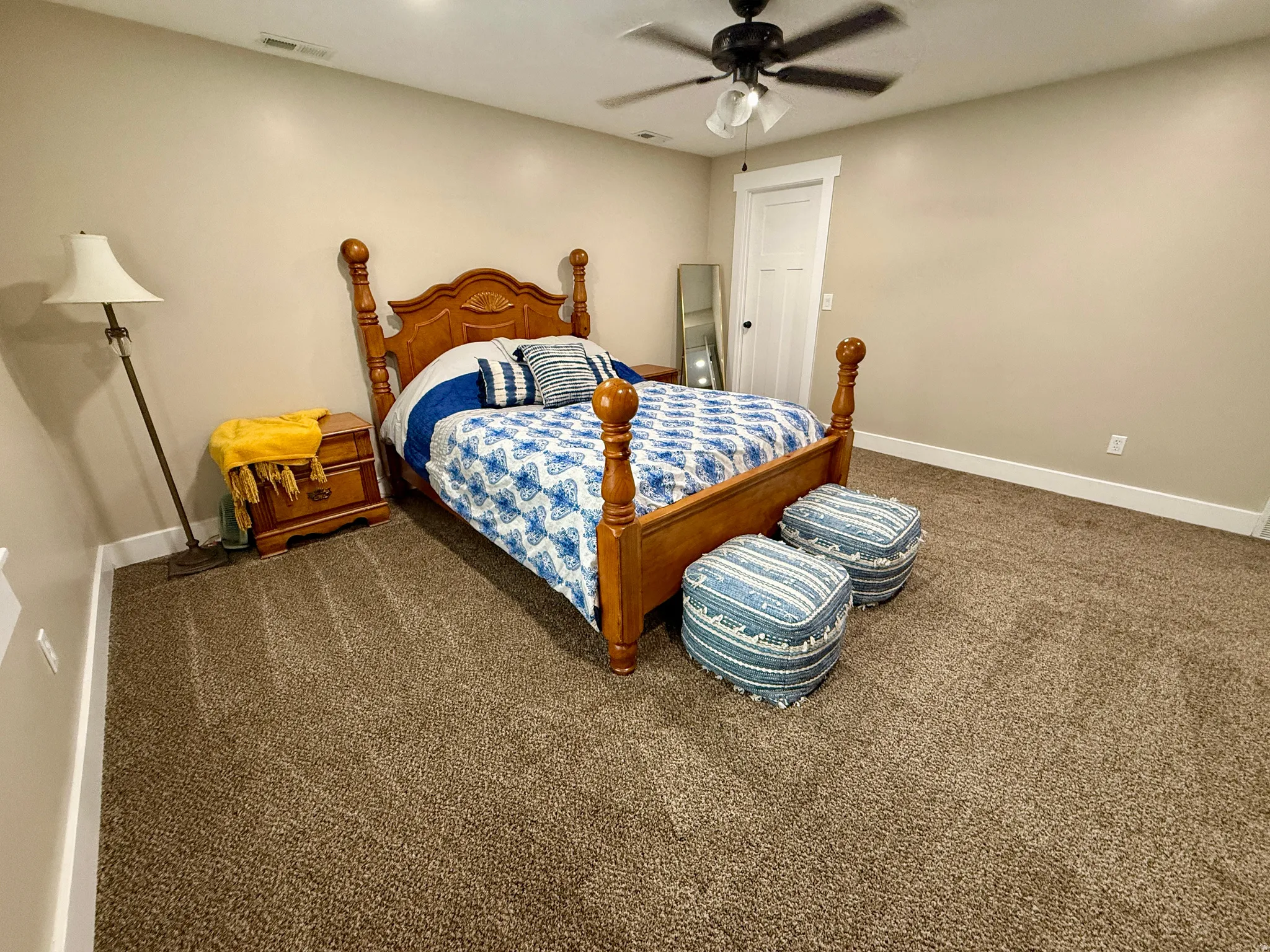 Spacious room featuring neutral painted walls and a textured carpet