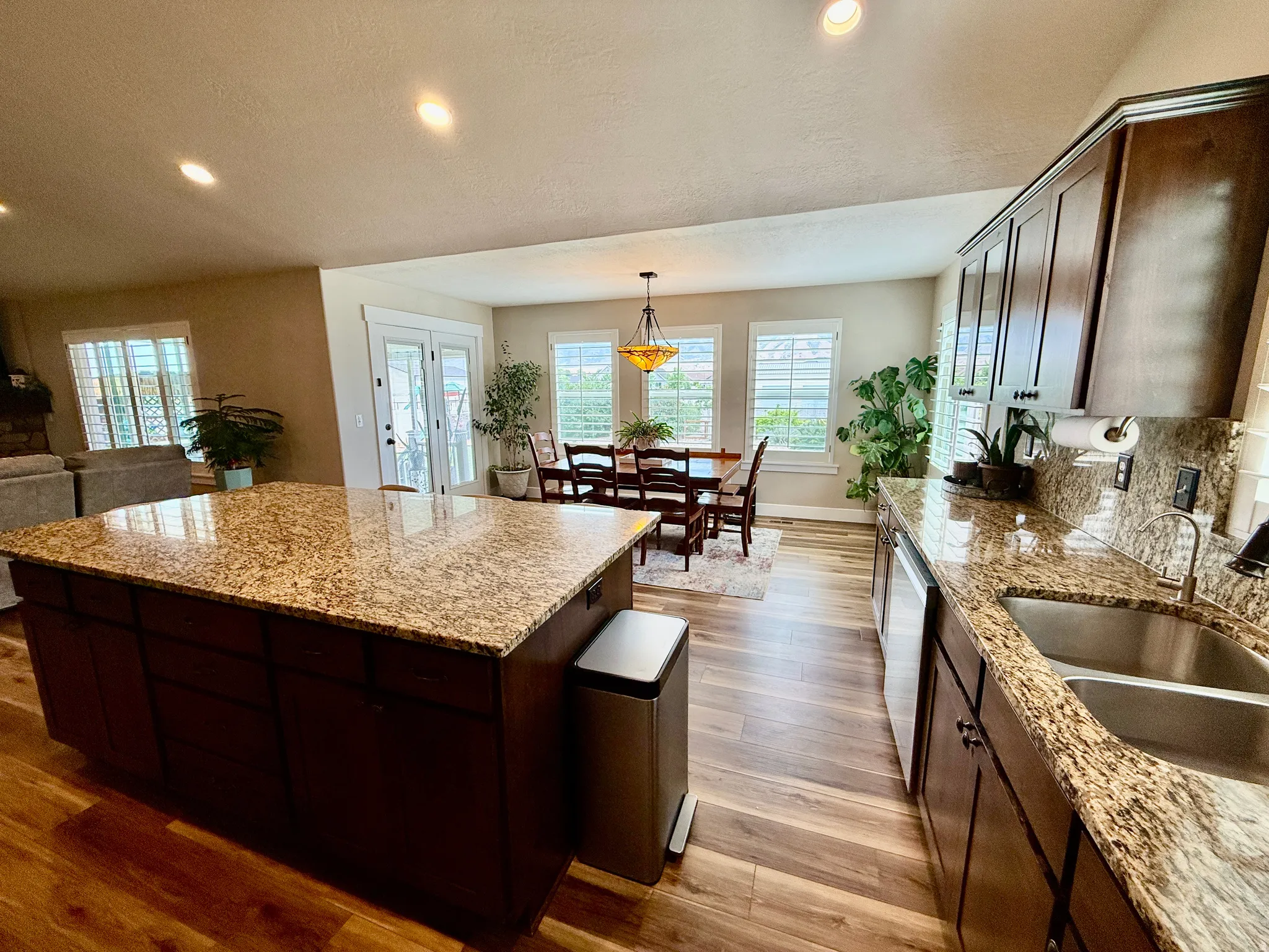 Expansive kitchen island with a granite countertop, complemented by dark wood cabinetry