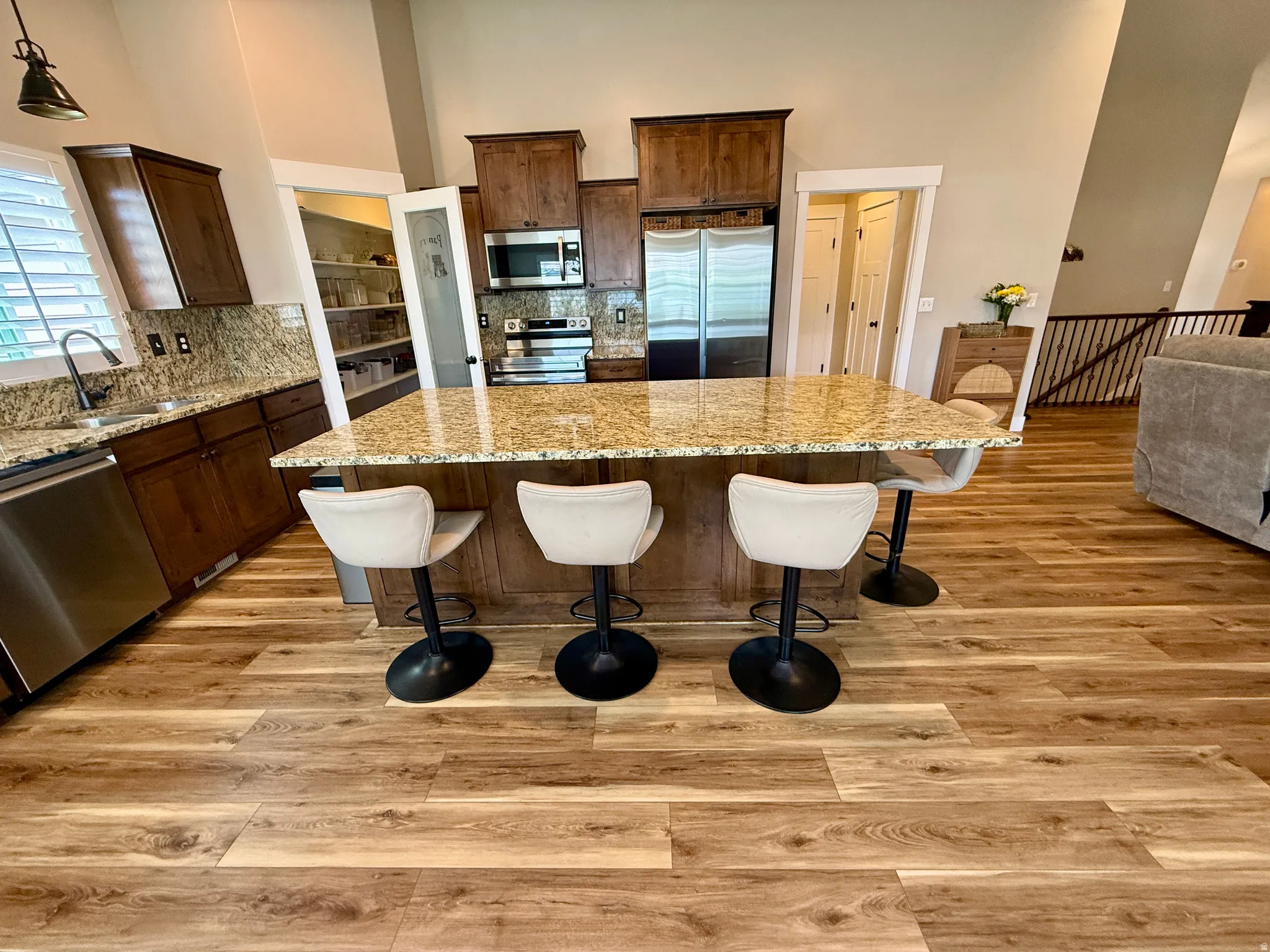 Kitchen featuring wood-finish flooring and a central island with a granite countertop