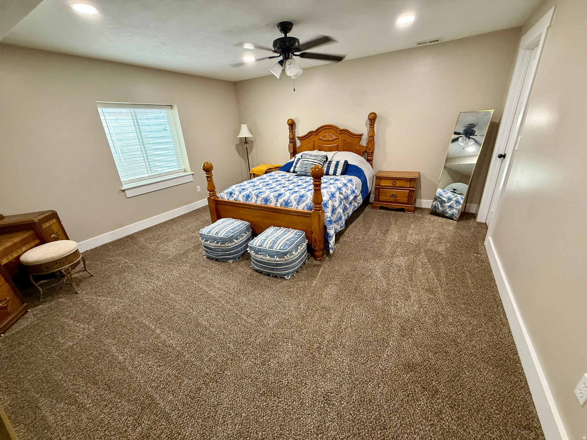 Spacious bedroom featuring neutral carpeting, recessed lighting, and a ceiling fan