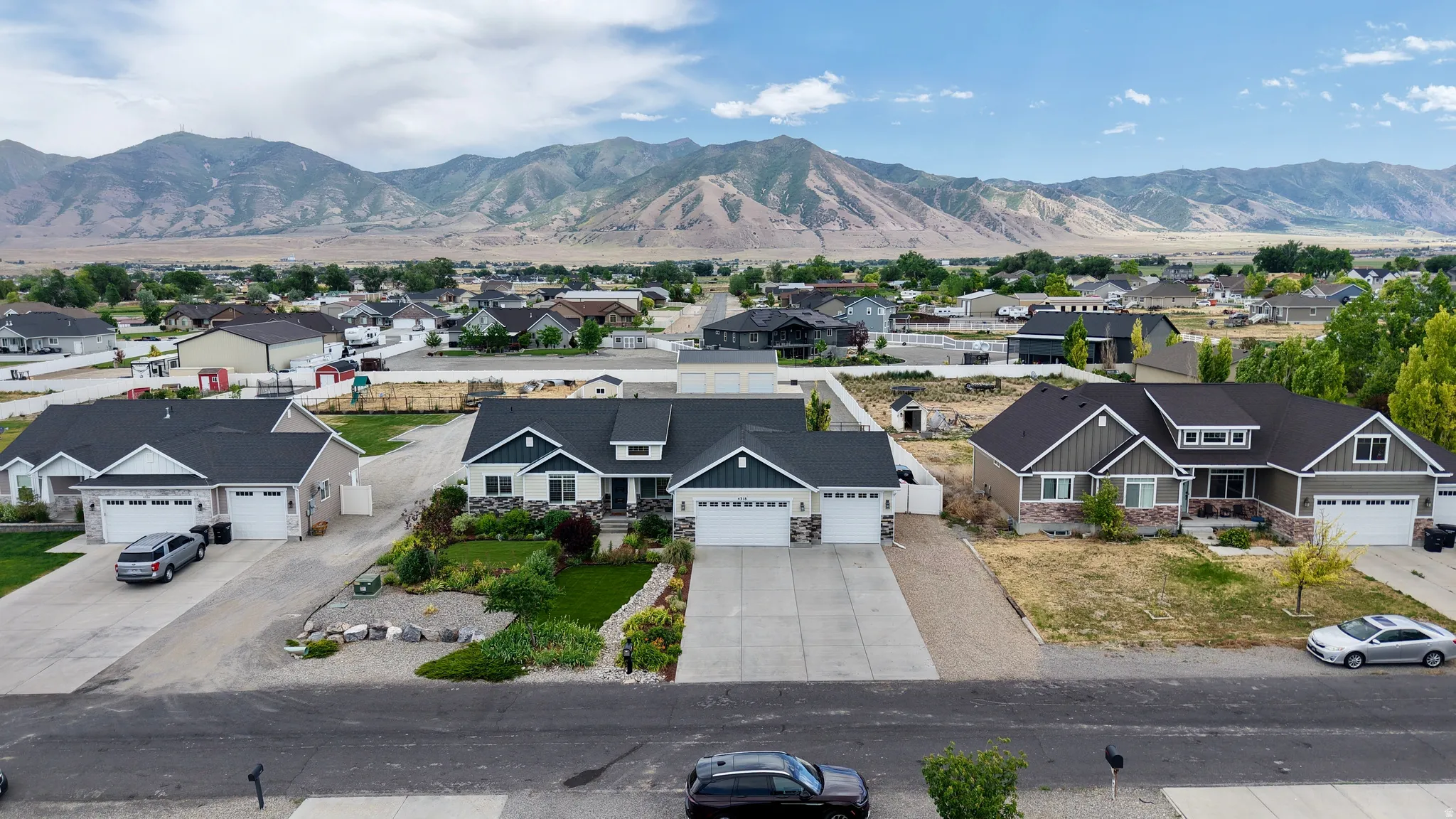 Modern ranch-style residence featuring a dark gray siding exterior, white trim, and a two-car garage